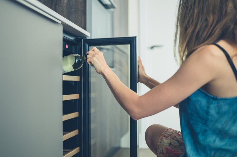 A Lady fixing the fridge