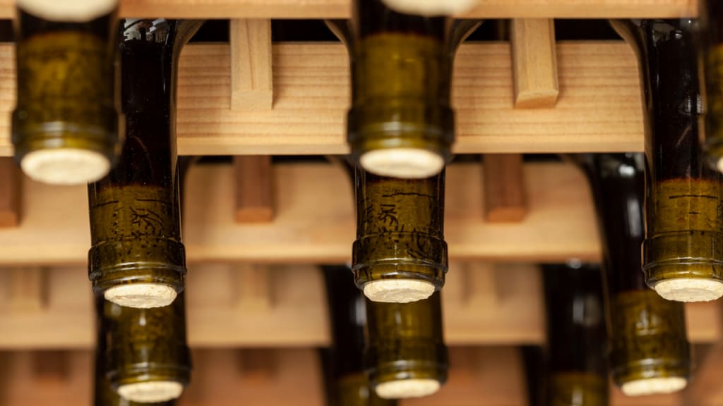 bottles without caps on a wine rack