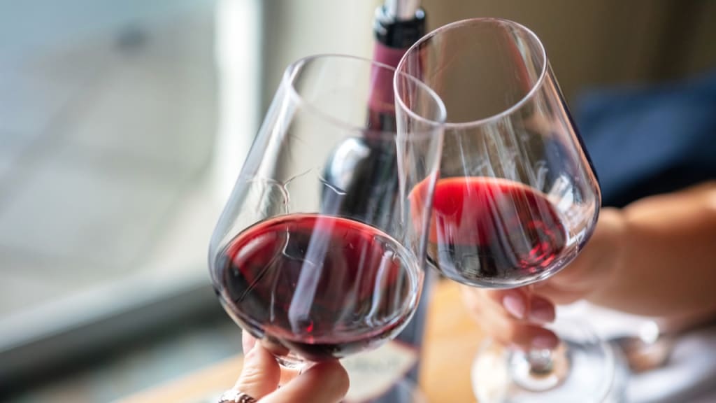 clinking with two glasses of red wine