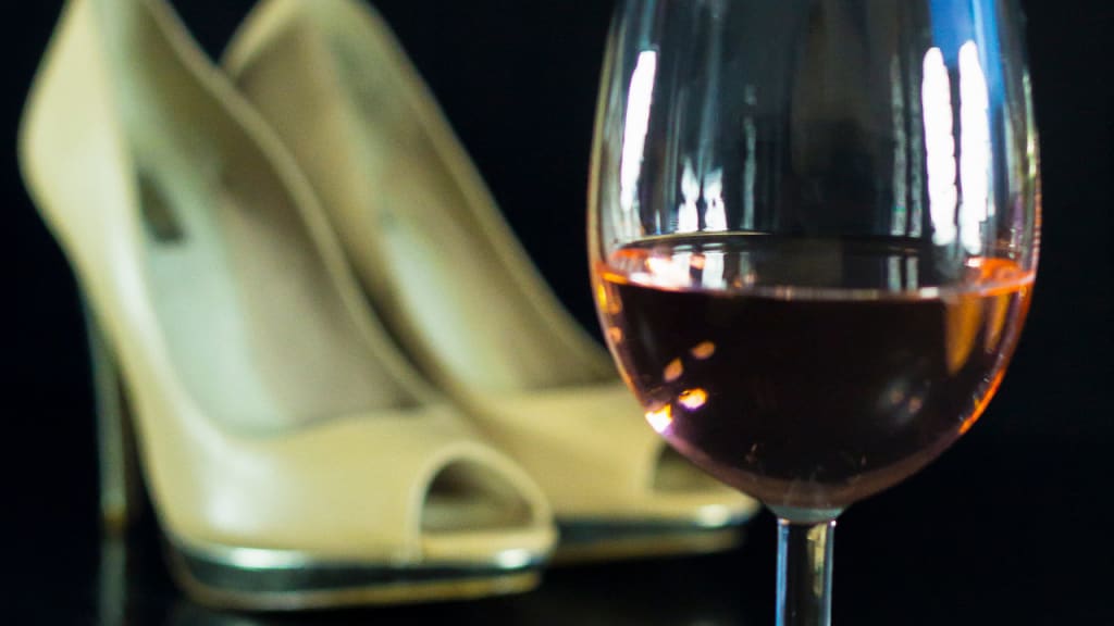 glass of rose wine and beige shoes