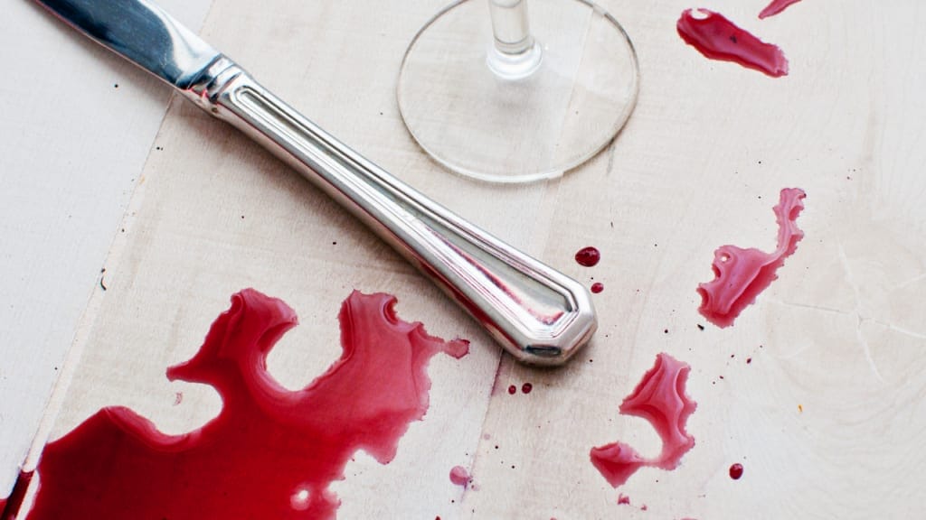 knife and spilled wine bottle