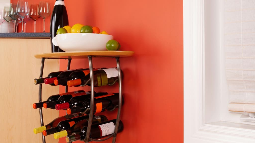 red wall with wine bottles and a wine rack