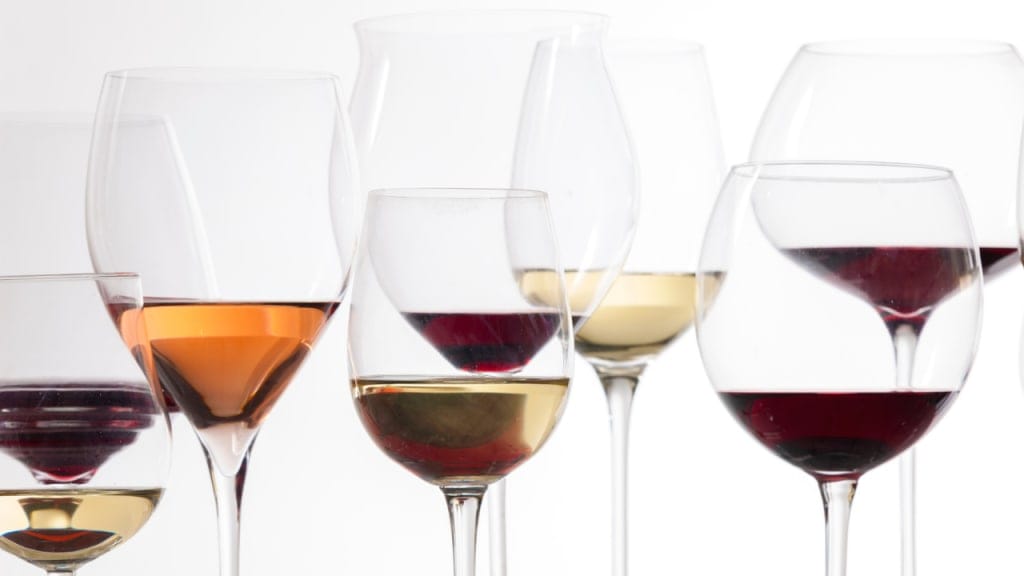 a lot of wine glasses filled with different wines